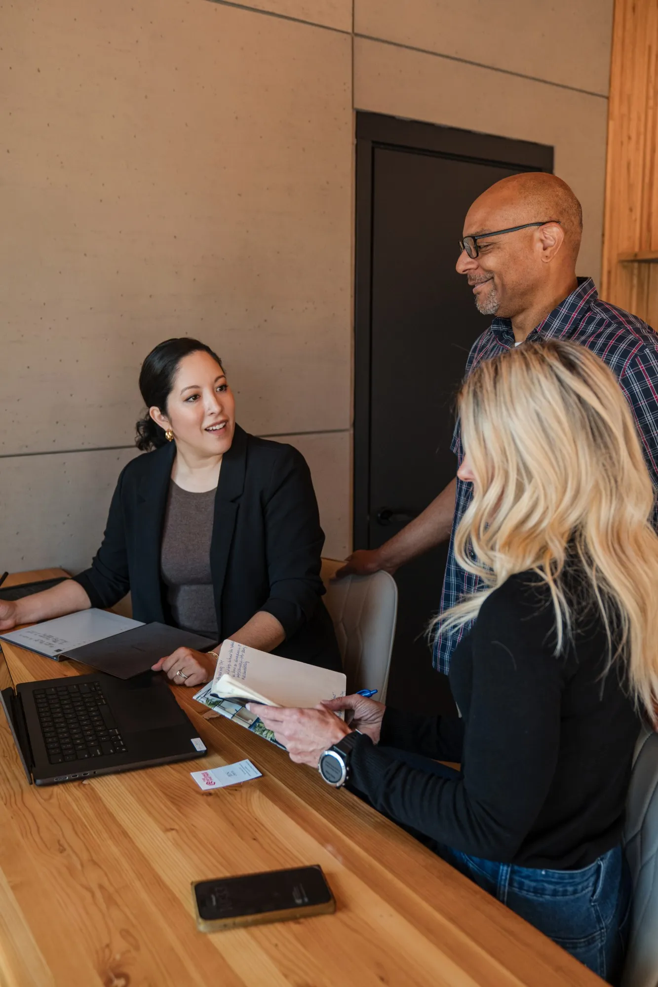 Jen Orvis talking with two clients at a table